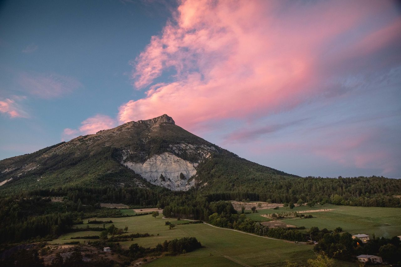 A breathtaking view of a mountain under a pink sunset sky in Provence-Alpes-Côte dAzur, France.